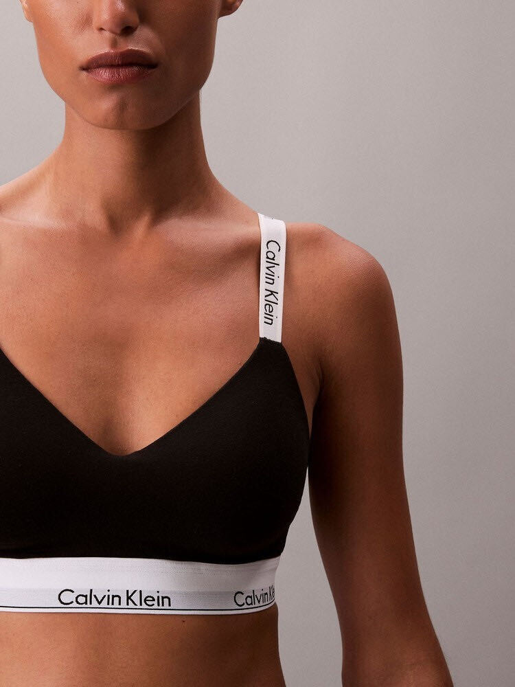 黒いブラレットを着用したモデル。白いストラップとアンダーバンドにCalvin Kleinのロゴが入った提供画像